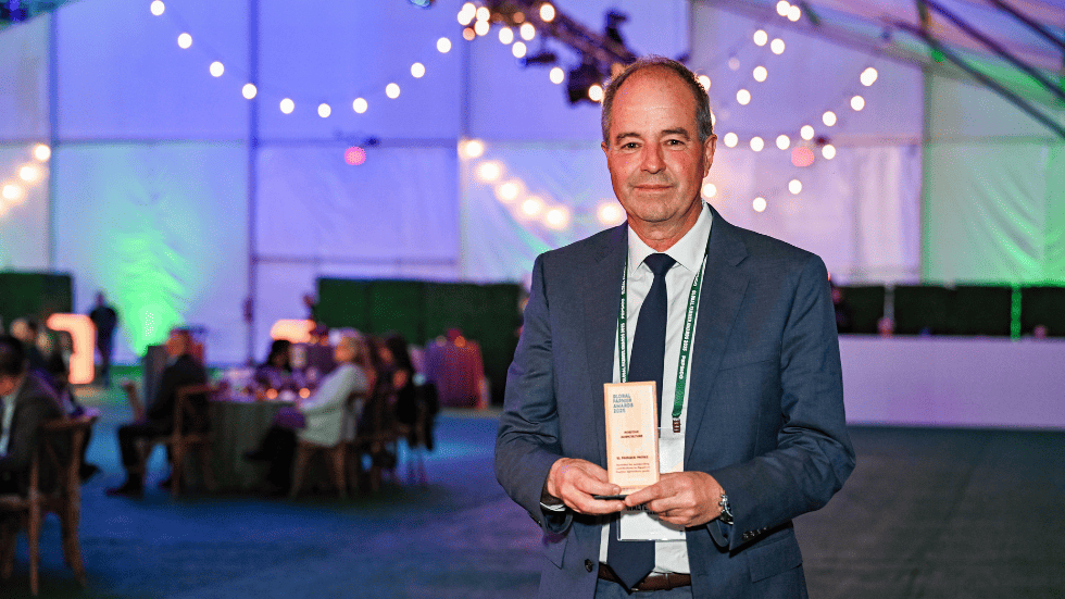 Walter Antonio Hernández mirando a cámara y sosteniendo el premio a la sostenibilidad que ganaron en el Global Farmer Awards de PepsiCo